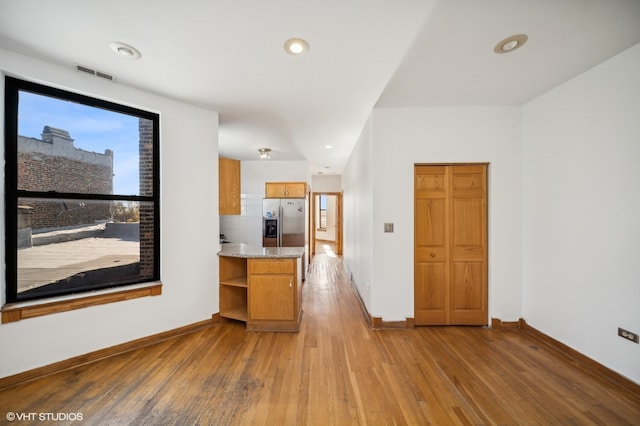 interior space featuring light hardwood / wood-style floors and stainless steel fridge with ice dispenser