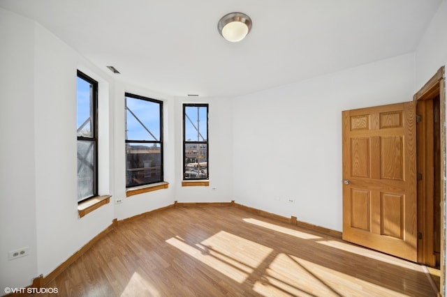 empty room with hardwood / wood-style flooring