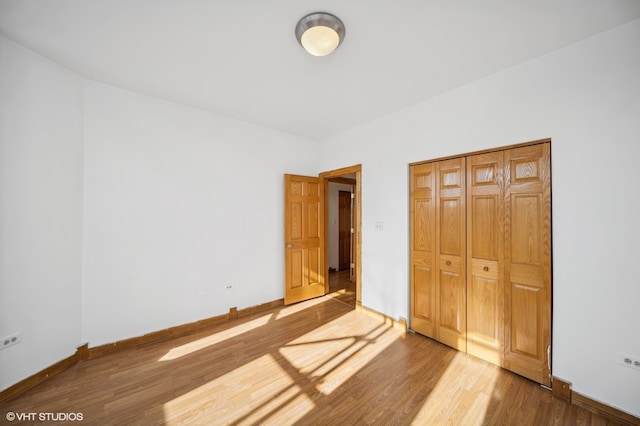 unfurnished bedroom featuring hardwood / wood-style floors and a closet