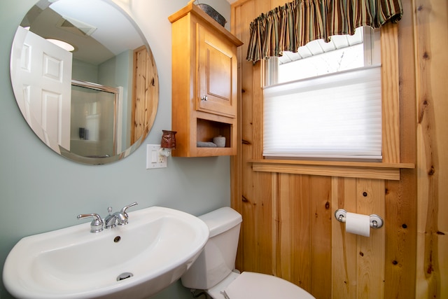 bathroom featuring toilet, walk in shower, and sink