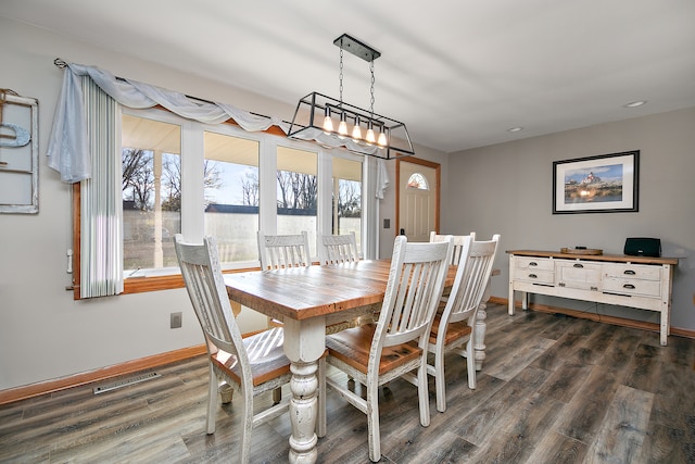 dining space with a chandelier and dark hardwood / wood-style floors