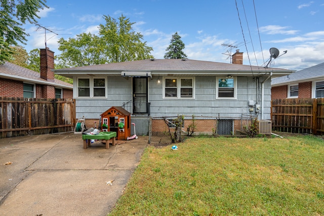 rear view of house with a lawn and central AC