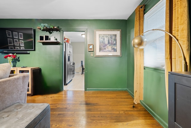 kitchen featuring stainless steel fridge, wood-type flooring, and a healthy amount of sunlight