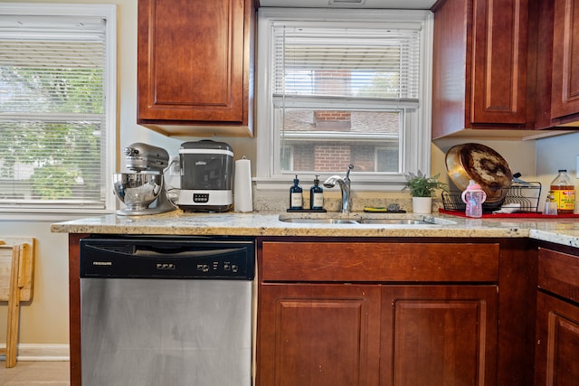 kitchen featuring stainless steel dishwasher, light stone counters, and sink