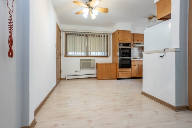 kitchen with light hardwood / wood-style flooring, black double oven, a wall unit AC, and a baseboard heating unit