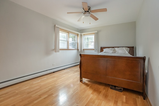 bedroom with ceiling fan, light hardwood / wood-style flooring, and a baseboard heating unit