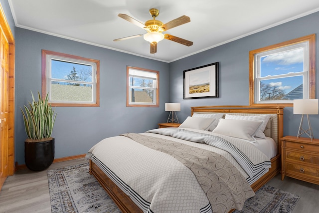 bedroom with ceiling fan, crown molding, light hardwood / wood-style flooring, and multiple windows