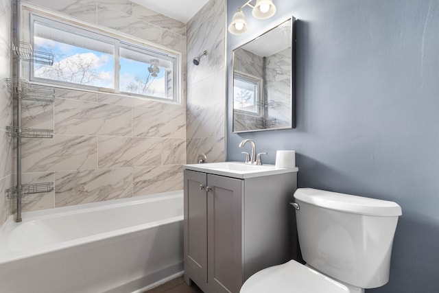 full bathroom featuring toilet, vanity, a healthy amount of sunlight, and tiled shower / bath