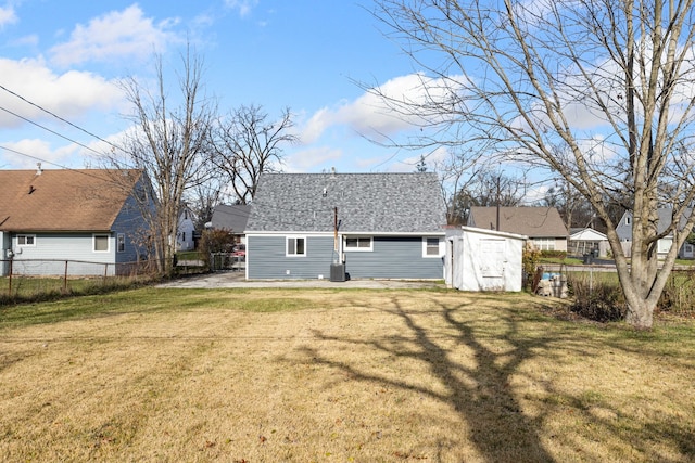 rear view of property featuring cooling unit and a lawn