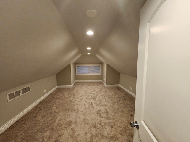 bonus room with light colored carpet and lofted ceiling