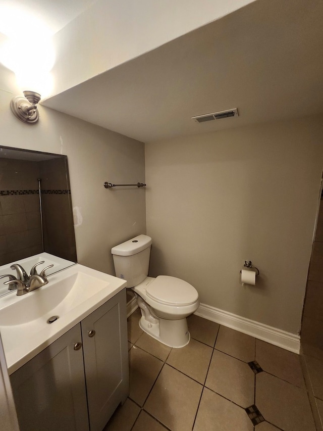 bathroom with tile patterned flooring, vanity, and toilet