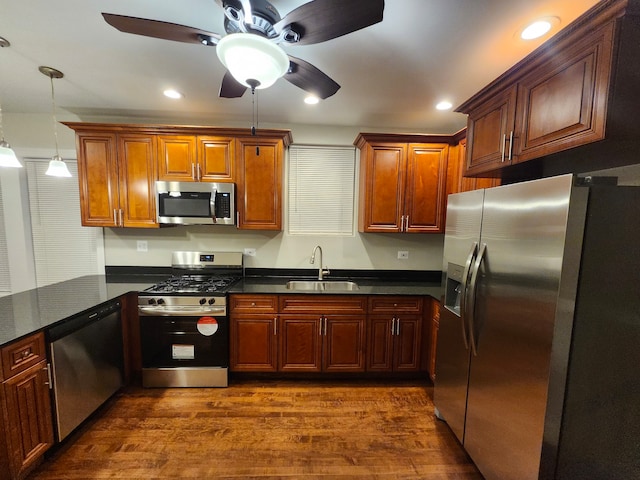 kitchen with pendant lighting, sink, dark hardwood / wood-style floors, ceiling fan, and stainless steel appliances