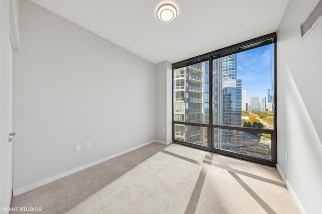 carpeted empty room featuring floor to ceiling windows