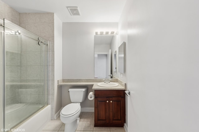 full bathroom with toilet, vanity, tile patterned floors, and bath / shower combo with glass door