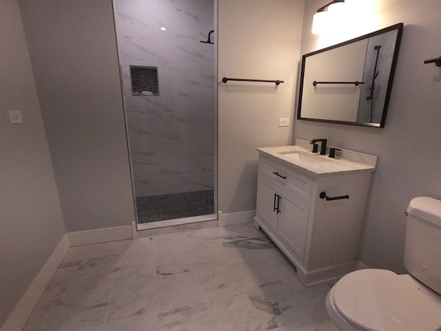 bathroom with a tile shower, vanity, and toilet