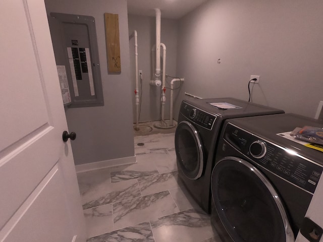 laundry room featuring electric panel and separate washer and dryer