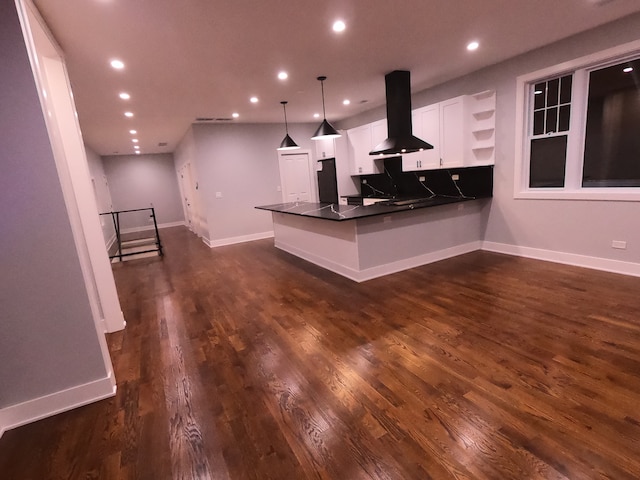 kitchen with white cabinets, hanging light fixtures, dark hardwood / wood-style floors, kitchen peninsula, and island exhaust hood