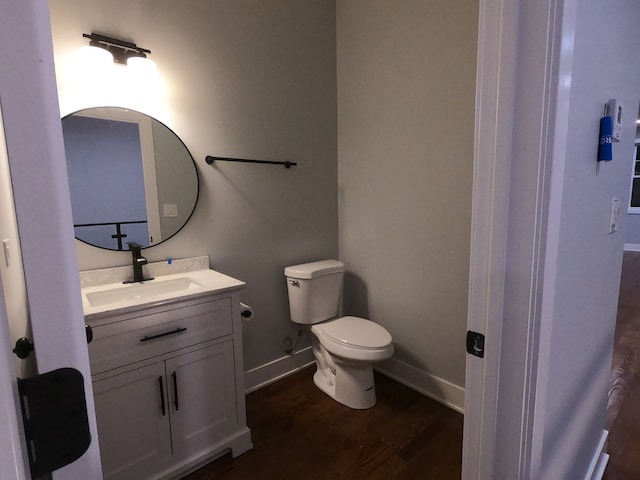 bathroom featuring vanity, wood-type flooring, and toilet