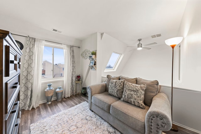 living room with hardwood / wood-style floors, a skylight, and ceiling fan