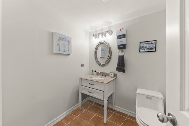 bathroom with tile patterned flooring, vanity, and toilet