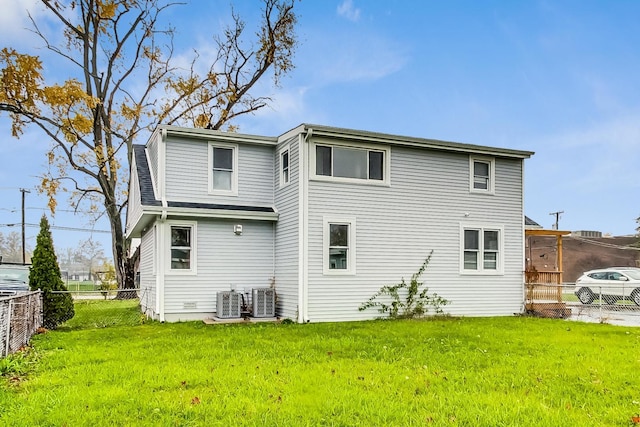 back of property with a lawn and central air condition unit