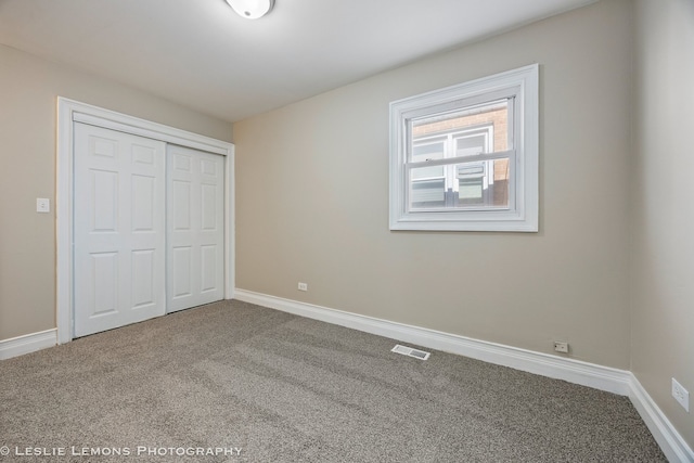 unfurnished bedroom with a closet and carpet floors