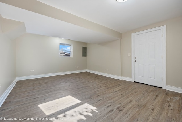 basement with light hardwood / wood-style floors and electric panel