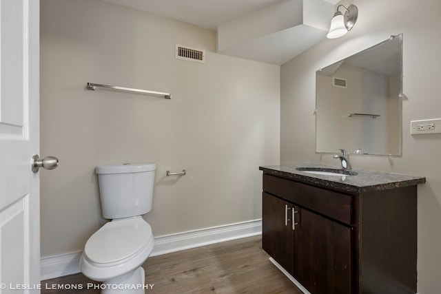 bathroom with vanity, wood-type flooring, and toilet