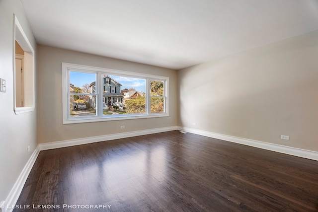 empty room with dark hardwood / wood-style flooring