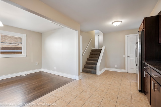 interior space with stainless steel fridge, light hardwood / wood-style floors, and dark brown cabinetry