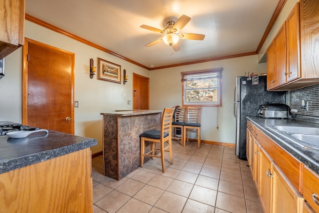 kitchen with ceiling fan, ornamental molding, and tasteful backsplash