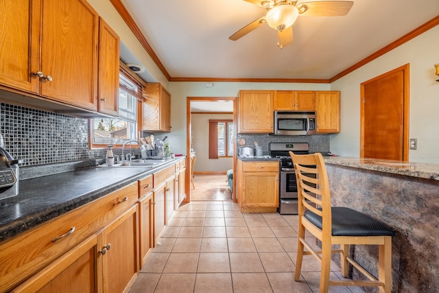 kitchen with tasteful backsplash, crown molding, light tile patterned flooring, and stainless steel appliances