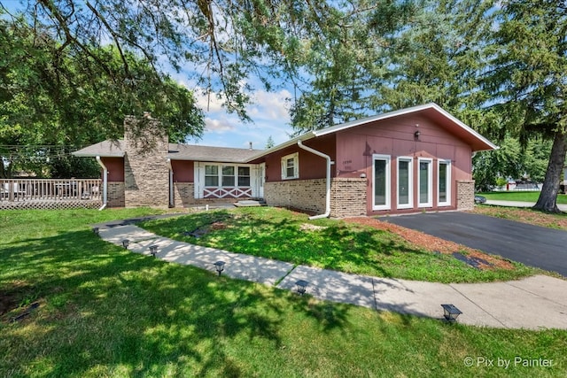 view of front facade featuring a front yard and a deck