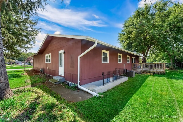 view of property exterior featuring a lawn, central AC unit, and a wooden deck