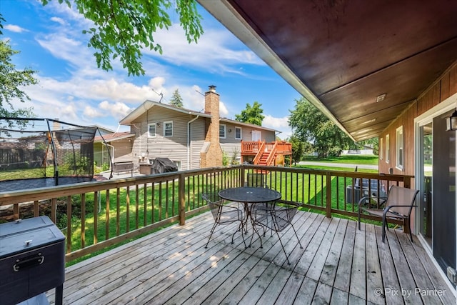 wooden terrace featuring a yard