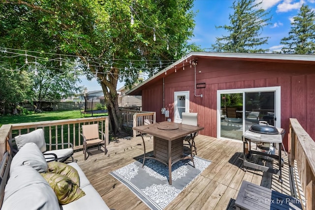 deck featuring an outdoor living space and a trampoline