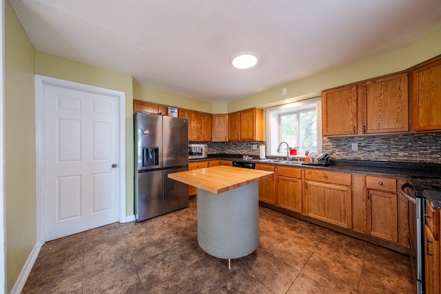 kitchen with wood counters, sink, stainless steel appliances, and tasteful backsplash