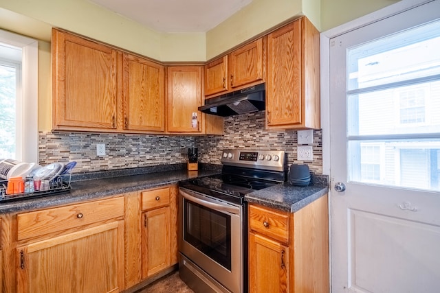 kitchen with decorative backsplash, plenty of natural light, and stainless steel range with electric stovetop