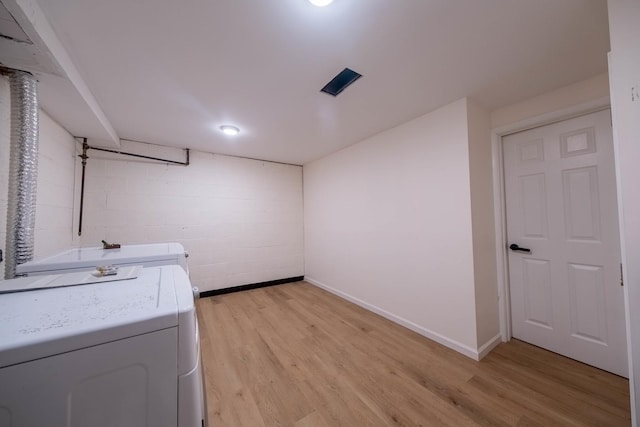 clothes washing area featuring light hardwood / wood-style floors and washer / clothes dryer