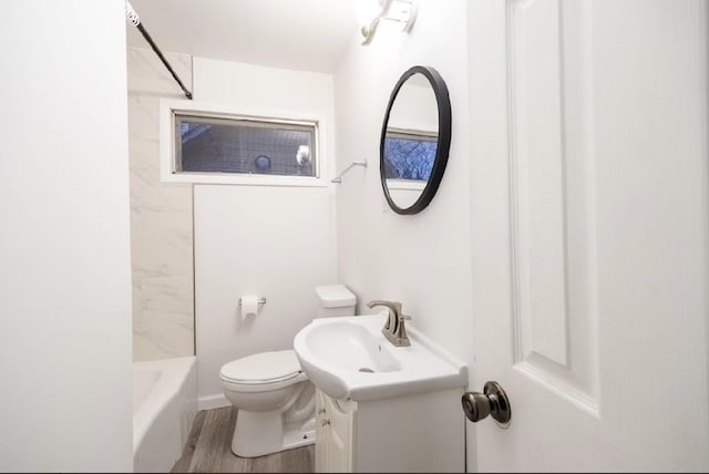 full bathroom with tiled shower / bath, toilet, vanity, and hardwood / wood-style flooring