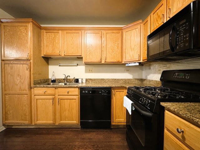 kitchen with dark stone counters, dark wood-type flooring, black appliances, and sink