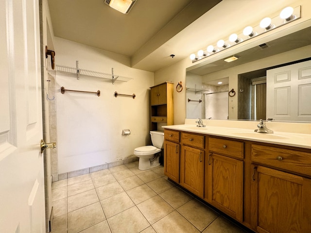 bathroom featuring tile patterned flooring, vanity, toilet, and a shower with door