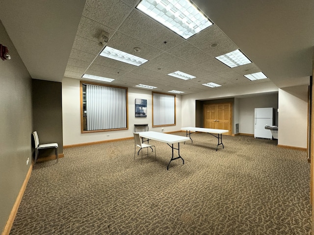 interior space with a paneled ceiling and carpet floors