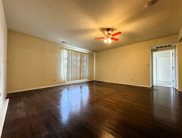 empty room featuring a textured ceiling, ceiling fan, and dark hardwood / wood-style floors