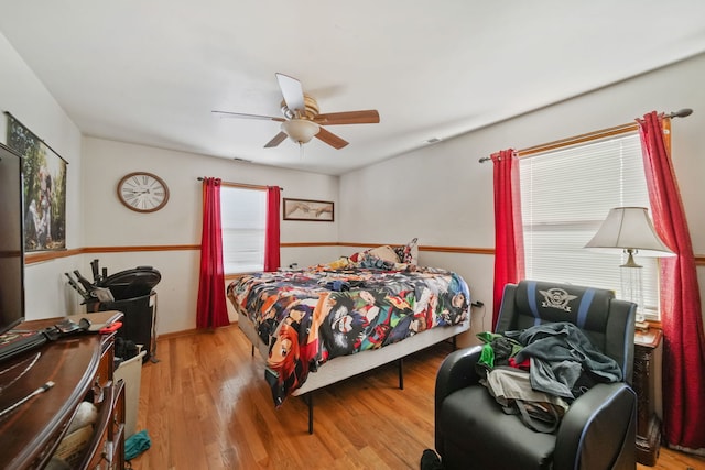 bedroom with light hardwood / wood-style flooring and ceiling fan