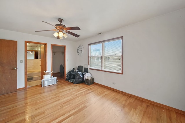 interior space featuring ceiling fan, a spacious closet, light hardwood / wood-style flooring, connected bathroom, and a closet