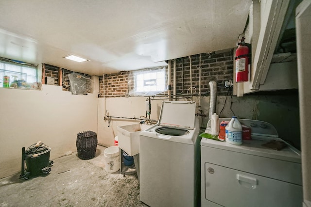 laundry room with washing machine and clothes dryer and sink