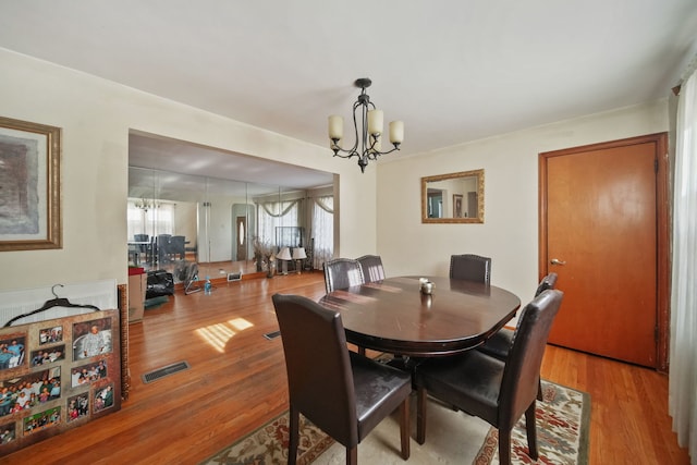 dining room featuring light hardwood / wood-style flooring and a notable chandelier