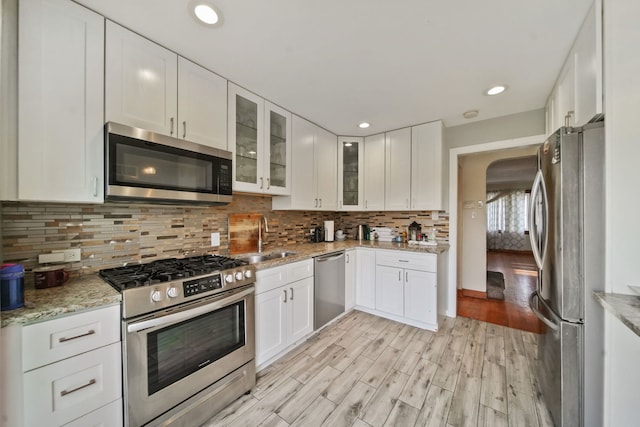 kitchen featuring sink, white cabinetry, stainless steel appliances, and light hardwood / wood-style flooring