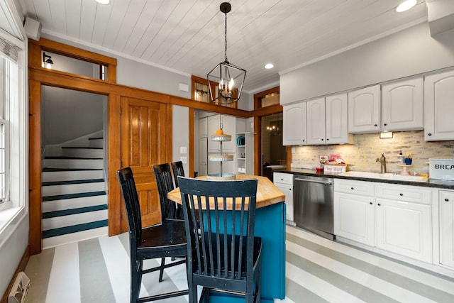 kitchen with white cabinetry, crown molding, decorative light fixtures, stainless steel dishwasher, and decorative backsplash